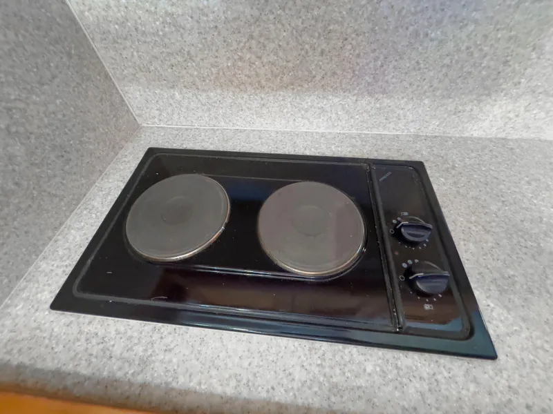 Slide: The Image of Electric stove in 2005 Mainship 34 Trawler kitchen, featuring dual burners and control knobs. - 17