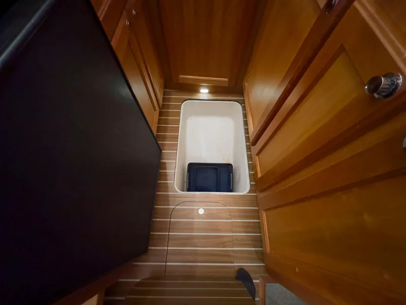 Slide: The Image of Mainship 34 Trawler 2005 interior with wooden flooring and storage compartment. - 19