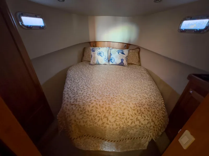 Slide: The Image of Cozy bedroom in 2005 Mainship 34 Trawler with floral bedding and nautical-themed pillows. - 20