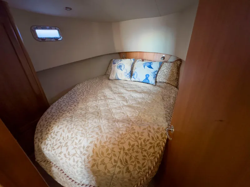 Slide: The Image of Cozy bedroom in 2005 Mainship 34 Trawler with floral bedding and nautical-themed pillows. - 22