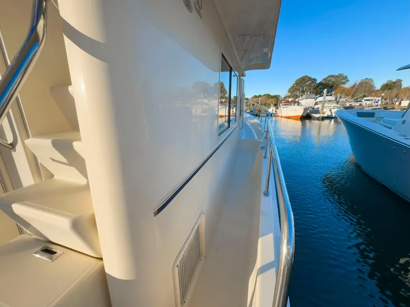 Slide: The Image of 2005 Mainship 34 Trawler docked, side view with clear blue sky and water. - 30