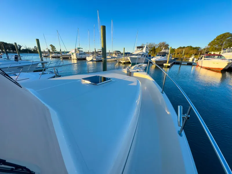 Slide: The Image of 2005 Mainship 34 Trawler docked in a marina under clear blue skies. - 31