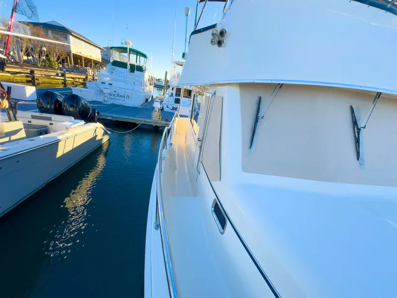 Slide: The Image of 2005 Mainship 34 Trawler docked at marina, surrounded by other boats. - 32