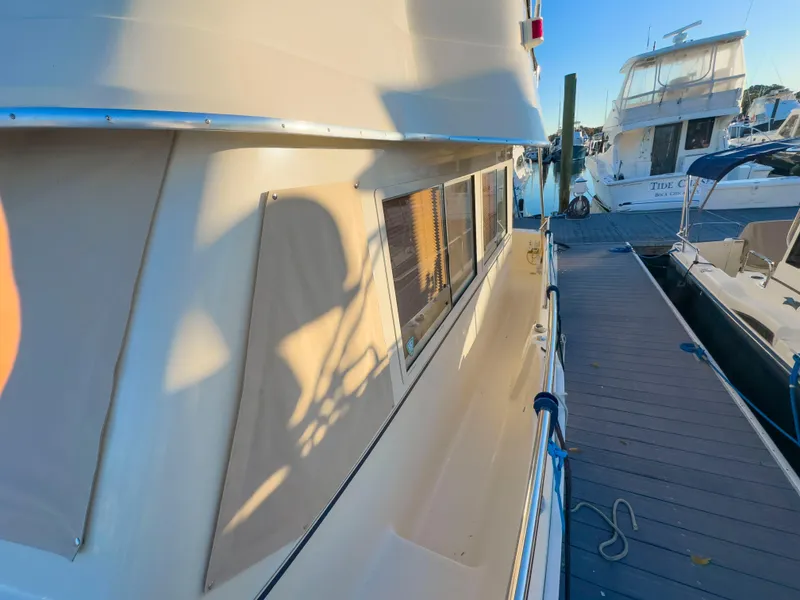 Slide: The Image of 2005 Mainship 34 Trawler docked at marina, side view with shadow. - 37