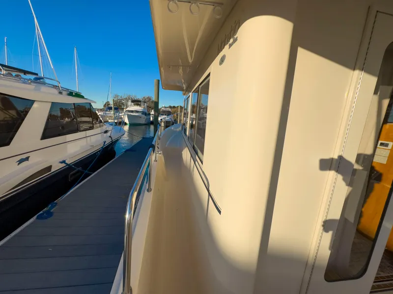 Slide: The Image of 2005 Mainship 34 Trawler docked at marina under clear blue sky. - 38