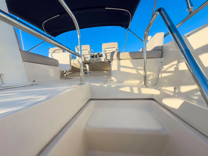 Slide: The Image of 2005 Mainship 34 Trawler deck with seating and canopy under clear blue sky. - 42