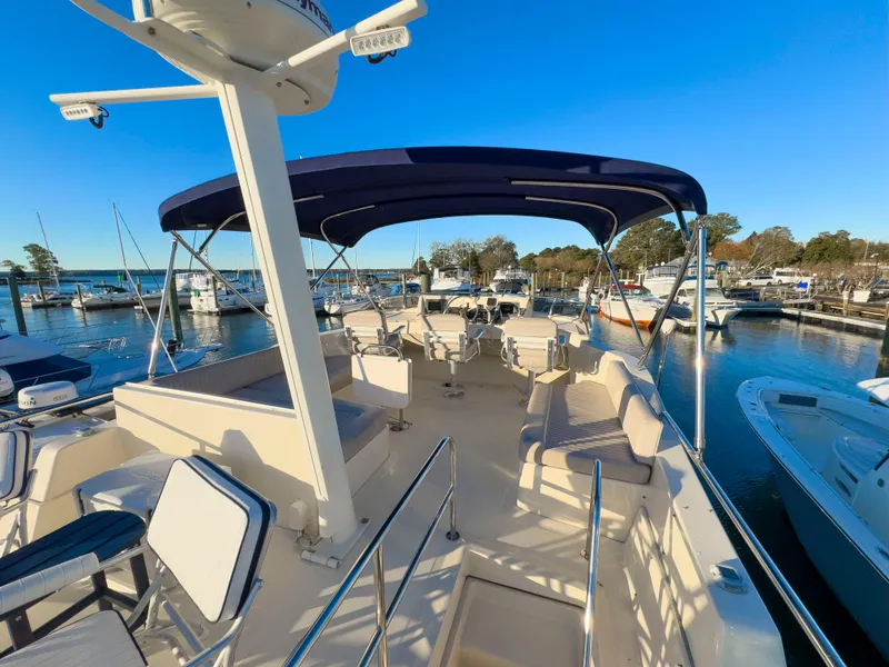 Slide: The Image of 2005 Mainship 34 Trawler with spacious deck and seating, docked at marina. - 43