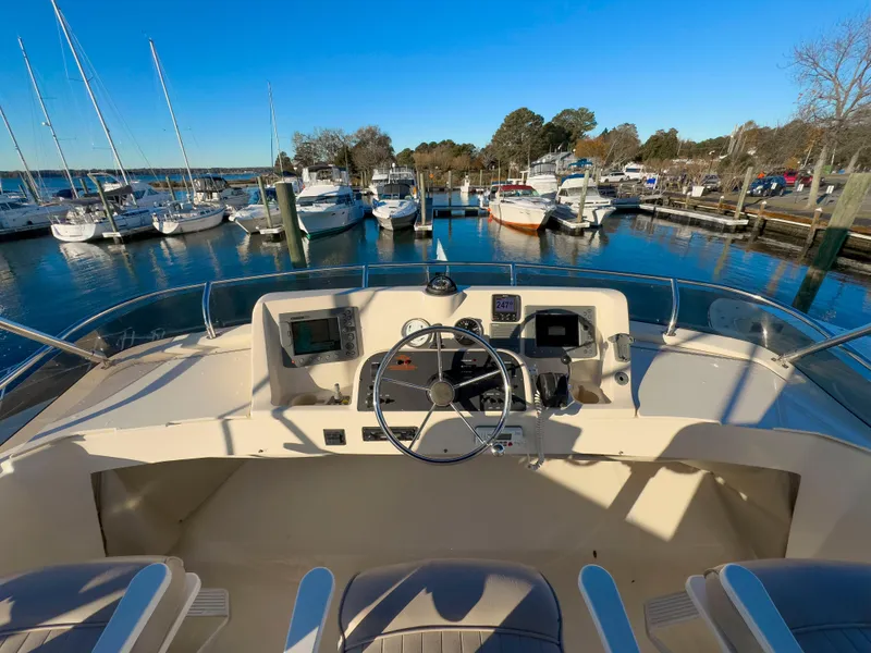 Slide: The Image of 2005 Mainship 34 Trawler helm view at marina, surrounded by boats. - 45