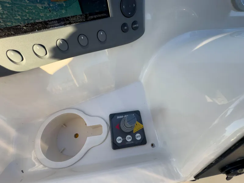 Slide: The Image of Control panel of a 2005 Mainship 34 Trawler with thruster switch and cup holder. - 47