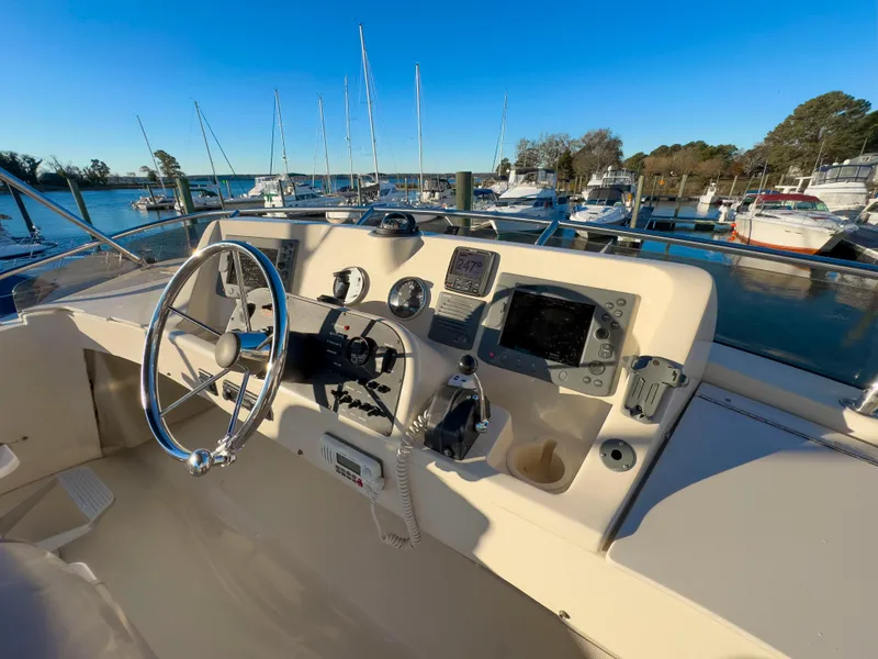 Slide: The Image of 2005 Mainship 34 Trawler helm with navigational instruments, docked at marina. - 49