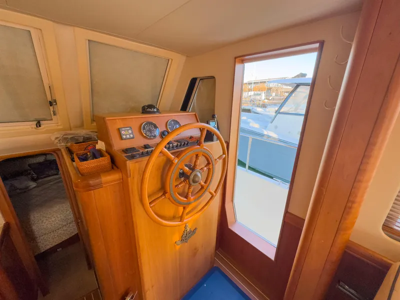Slide: The Image of 2005 Mainship 34 Trawler helm with wooden steering wheel and gauges. - 7