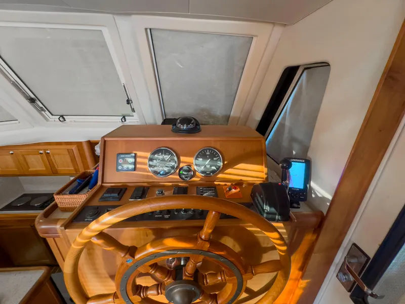 Slide: The Image of 2005 Mainship 34 Trawler helm with wooden wheel and navigation instruments. - 8
