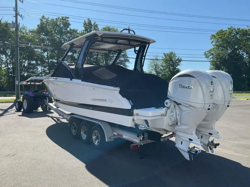 Slide: The Image of 2025 Chaparral 310 OSX boat on trailer with Yamaha engines, parked outdoors. - 10