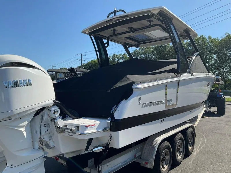 Slide: The Image of 2025 Chaparral 310 OSX boat on trailer with Yamaha engine, covered and parked outdoors. - 11