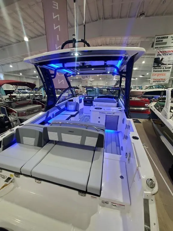 Slide: The Image of 2025 Chaparral 310 OSX boat interior with blue LED lighting in showroom. - 15
