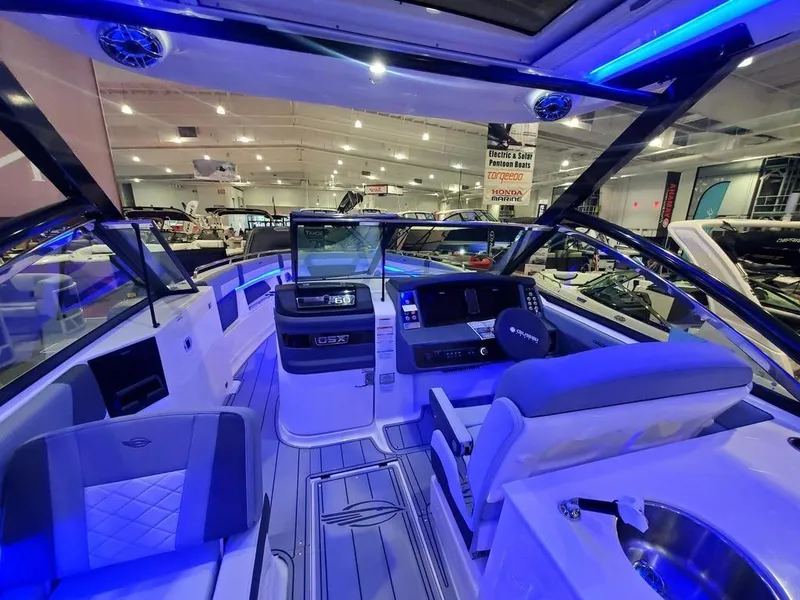 Slide: The Image of 2025 Chaparral 310 OSX boat interior with modern dashboard and blue ambient lighting. - 22