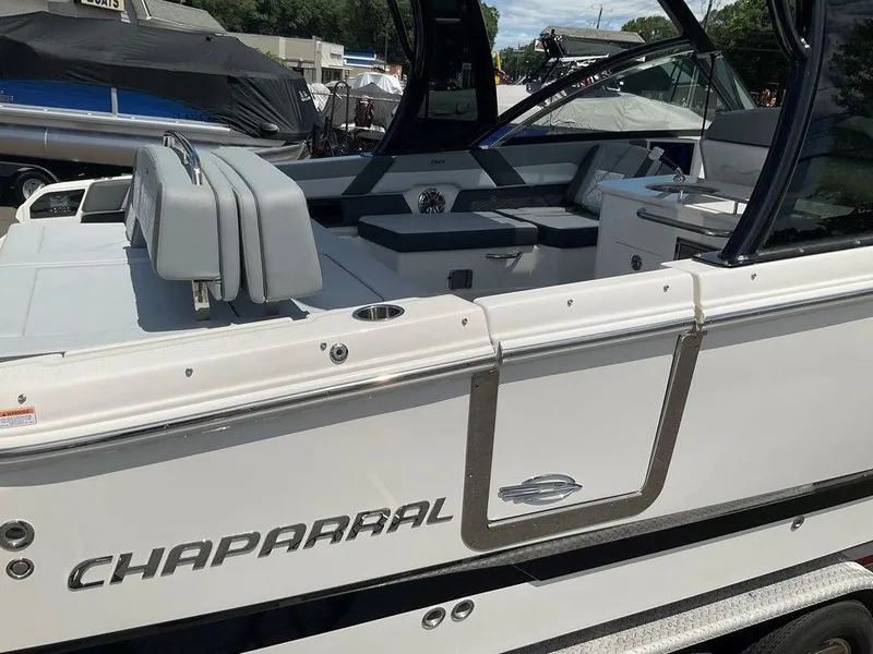 Slide: The Image of 2025 Chaparral 310 OSX boat, white exterior, luxury seating, docked outdoors. - 32