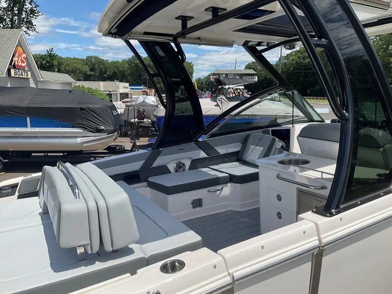Slide: The Image of 2025 Chaparral 310 OSX boat interior with seating and kitchenette at A&S Boats dealership. - 33