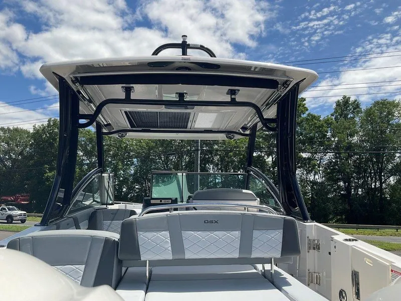 Slide: The Image of 2025 Chaparral 310 OSX boat interior with sleek seating and modern design under a blue sky. - 35