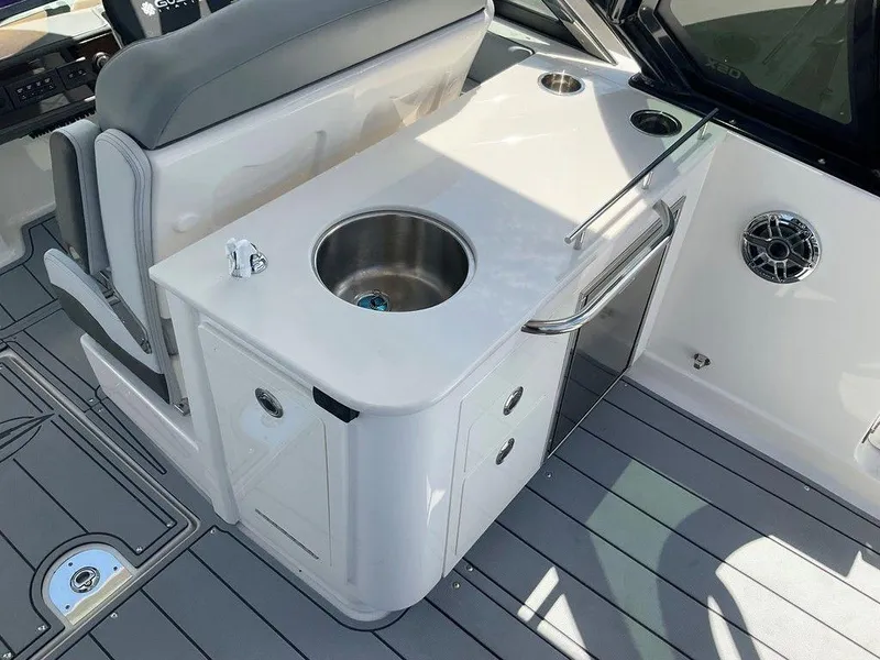 Slide: The Image of 2025 Chaparral 310 OSX boat interior with sink and storage area. - 46