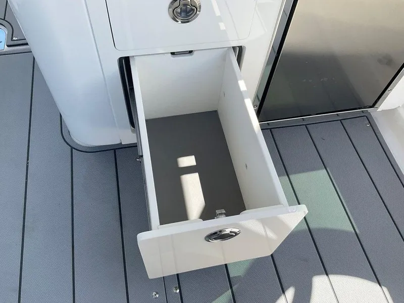 Slide: The Image of Open storage drawer on 2025 Chaparral 310 OSX boat deck. - 49
