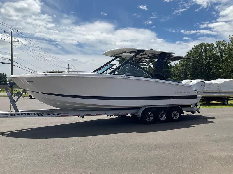 Slide: The Image of 2025 Chaparral 310 OSX boat on trailer under blue sky. - 9