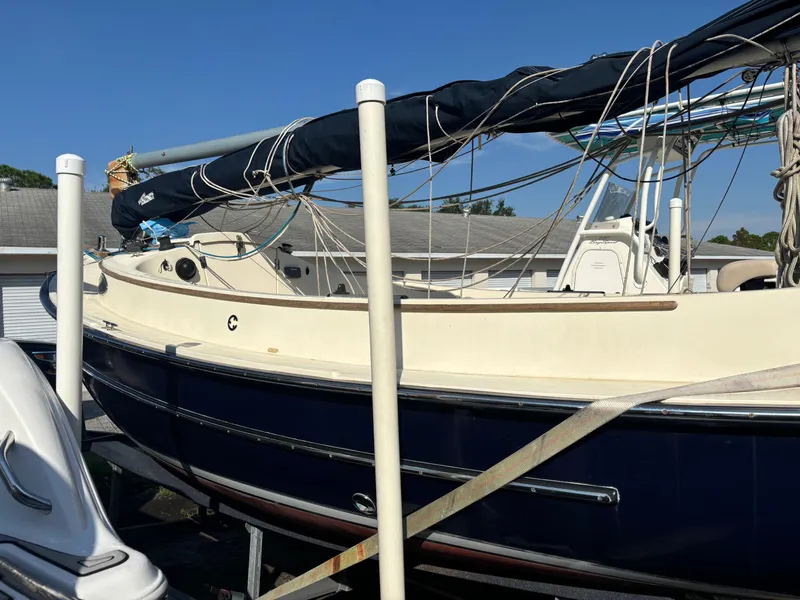 Slide: The Image of 2014 Com-Pac Horizon Day Cat sailboat on trailer, blue hull, docked outdoors. - 5