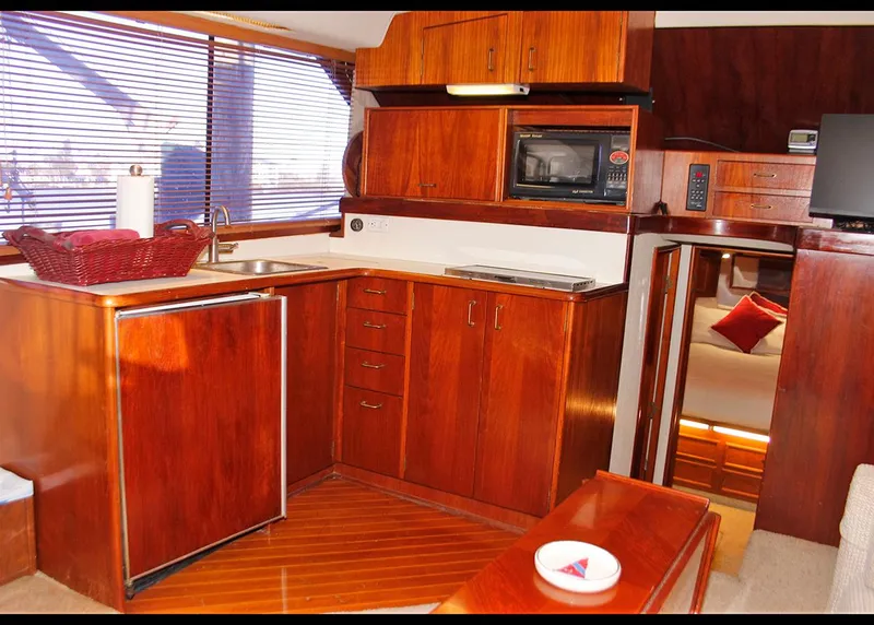 Slide: The Image of 1988 Ocean Yachts 38 Super Sport kitchen with wood cabinetry and modern appliances. - 13