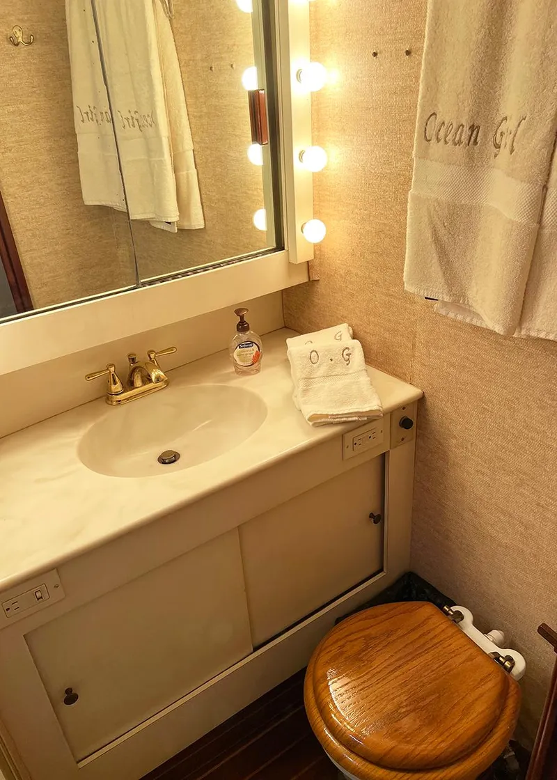 Slide: The Image of 1988 Ocean Yachts 38 Super Sport bathroom with vanity, mirror, and wooden toilet seat. - 19