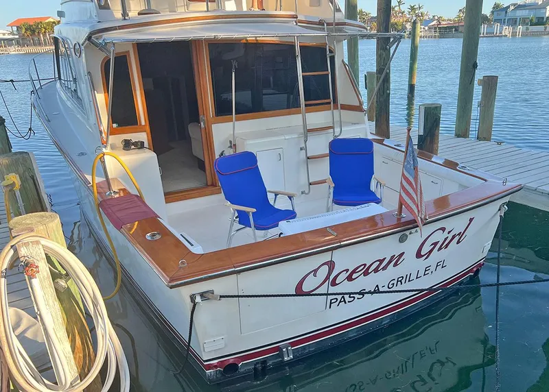 Slide: The Image of 1988 Ocean Yachts 38 Super Sport docked, featuring "Ocean Girl" name and blue chairs. - 4