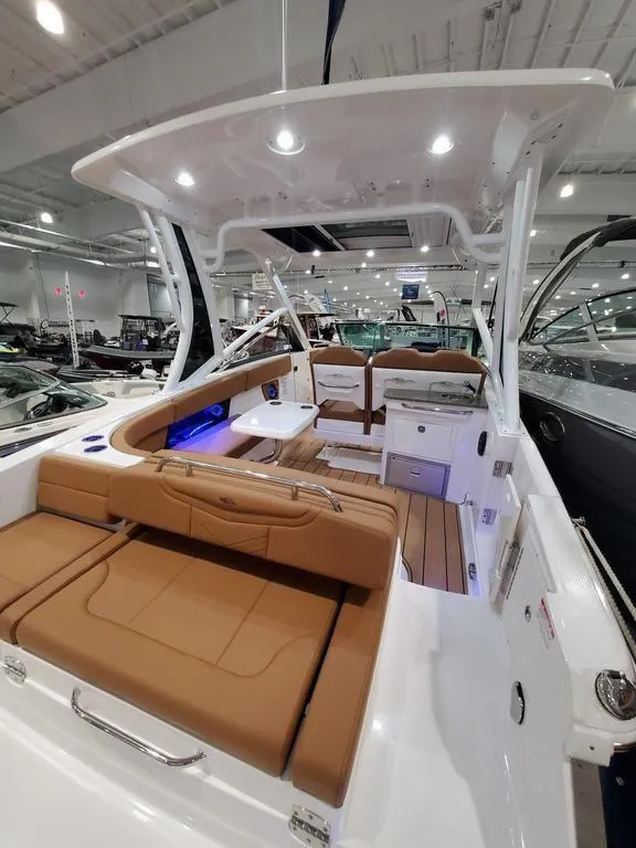 Slide: The Image of 2025 Chaparral 280 OSX boat interior with tan seating and modern amenities. - 3