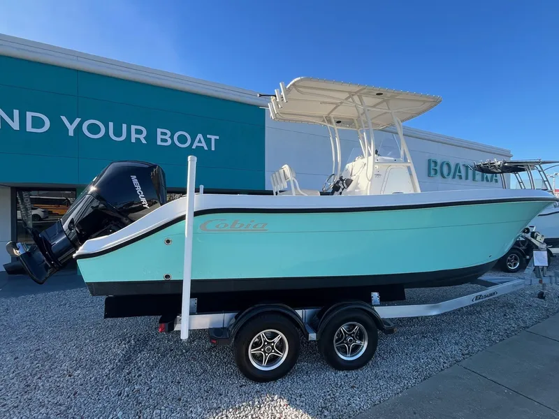 The Image of 2022 Cobia 237 Center Console boat on trailer, displayed outside dealership. - 0