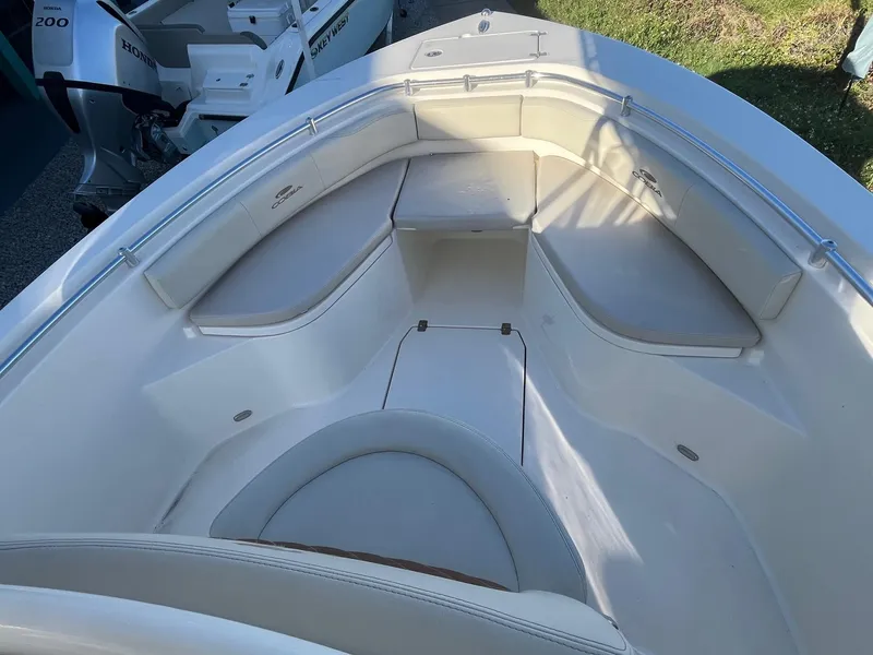 Slide: The Image of 2022 Cobia 237 Center Console boat interior with cushioned seating and storage compartments. - 2