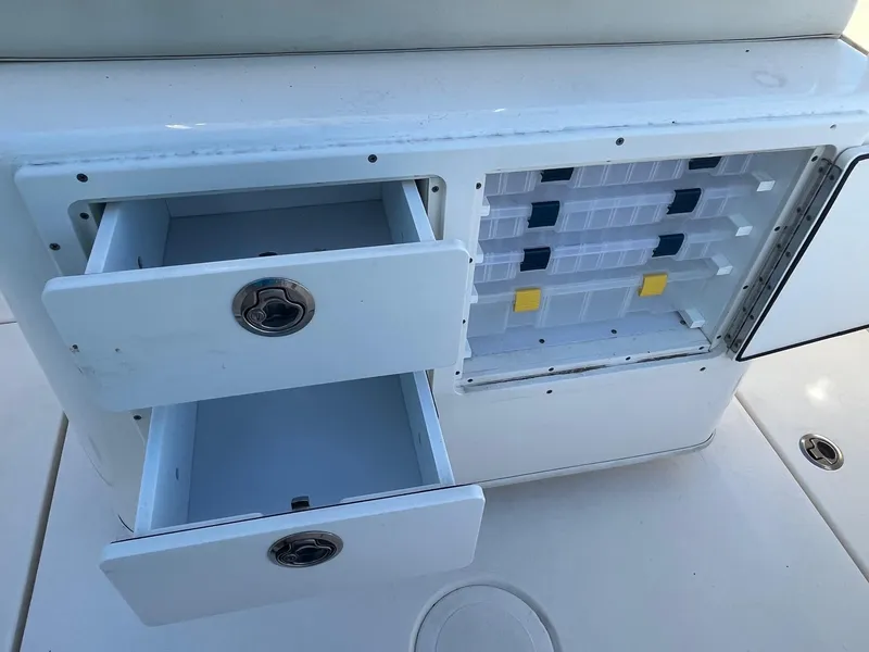 Slide: The Image of 2022 Cobia 237 Center Console storage compartments with open drawers and tackle boxes. - 5