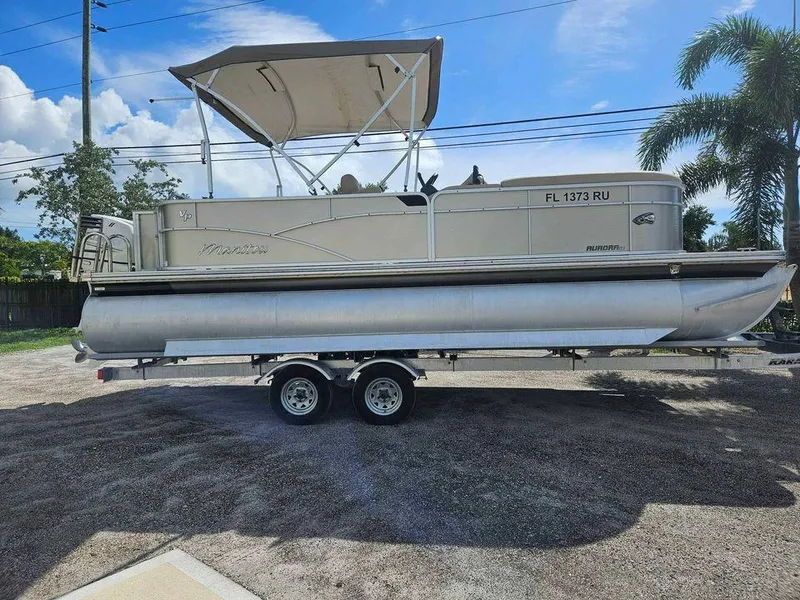 The Image of 2019 Manitou 22 Aurora LE 220VP Tritoon Pontoon on trailer, parked outdoors. - 0