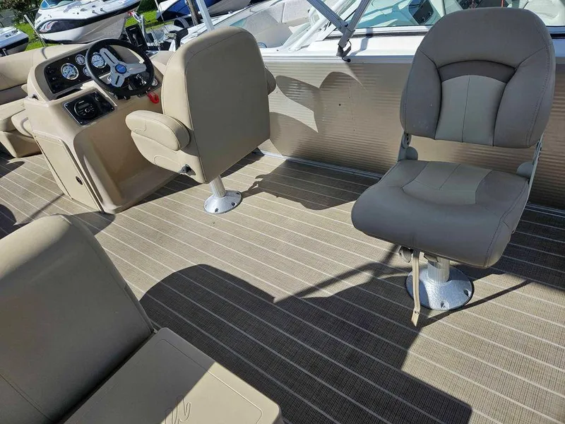 Slide: The Image of 2019 Manitou 22 Aurora LE 220VP Tritoon Pontoon interior with beige seating and steering console. - 5