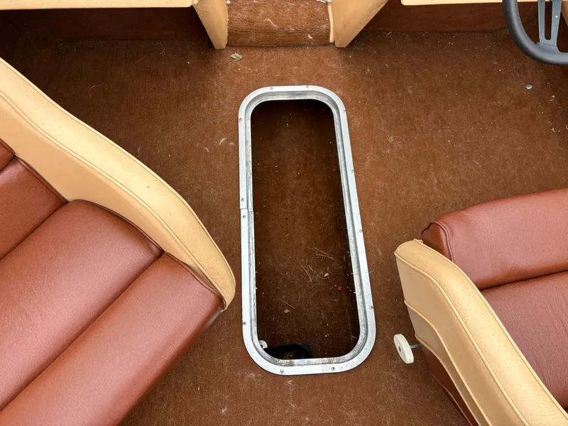 Slide: The Image of 1984 Chris-Craft 186 BR Scorpion interior with brown seats and open floor compartment. - 2