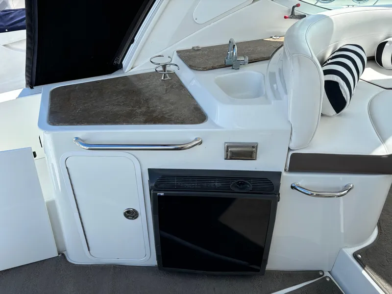 Slide: The Image of 2011 Cruisers Yachts 330 Express interior with sink, counter, and seating area. - 10