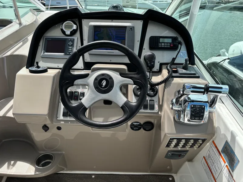 Slide: The Image of 2011 Cruisers Yachts 330 Express helm with steering wheel and navigation controls. - 13