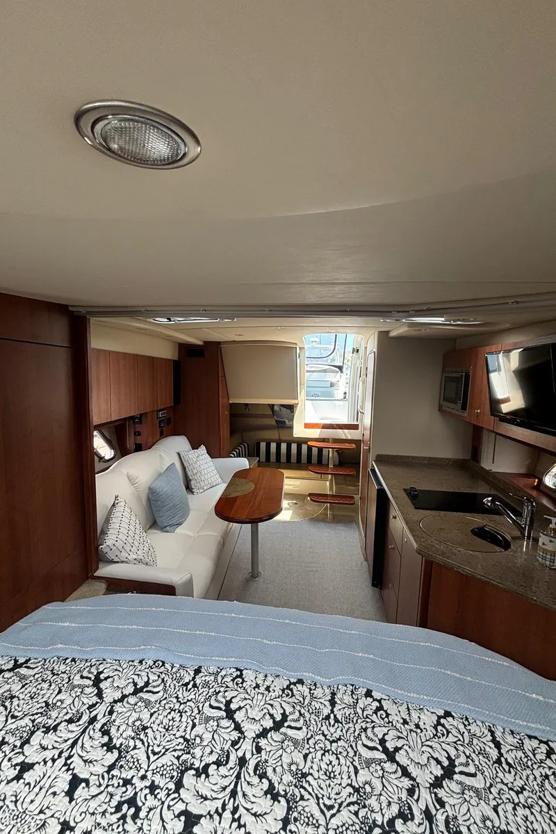 Slide: The Image of Interior of 2011 Cruisers Yachts 330 Express, featuring a cozy cabin and kitchenette. - 25