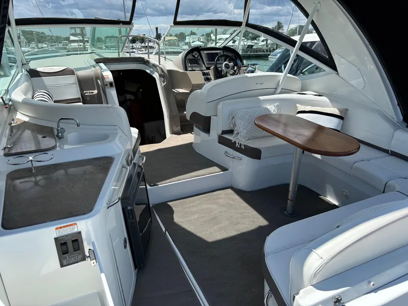 Slide: The Image of 2011 Cruisers Yachts 330 Express interior with seating, table, and helm. - 8
