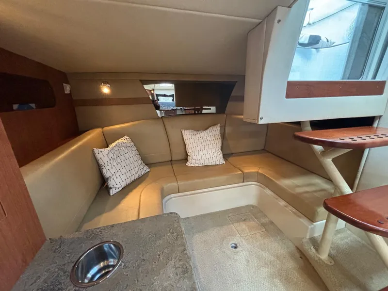 Slide: The Image of 2011 Cruisers Yachts 330 Express cabin interior with beige seating and modern amenities. - 21