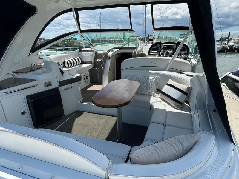 Slide: The Image of 2011 Cruisers Yachts 330 Express interior with seating, table, and helm at marina. - 9