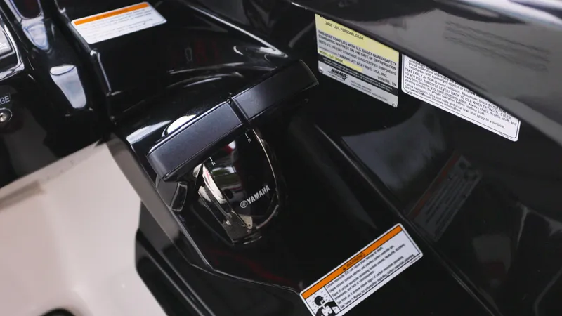 Slide: The Image of Close-up of 2018 Yamaha Boats 242 XE throttle control with safety labels. - 10