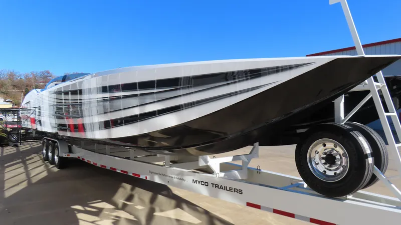 Slide: The Image of 2020 MTI 48 boat on Myco trailer, sleek design, parked outdoors. - 4