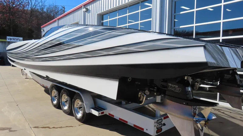 Slide: The Image of 2020 MTI 48 powerboat on trailer, sleek design, parked outside a garage. - 9