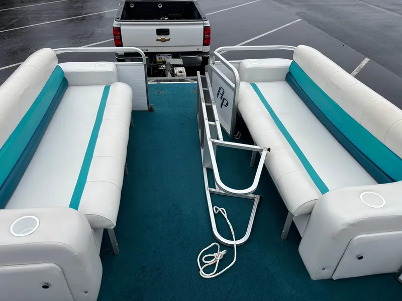 Slide: The Image of 1996 Godfrey Aqua Patio pontoon boat interior with teal and white seating. - 2