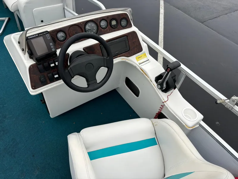 Slide: The Image of 1996 Godfrey Aqua Patio boat dashboard with steering wheel and controls. - 3