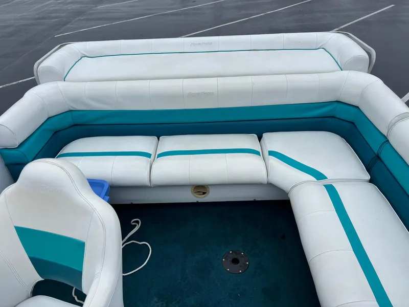 Slide: The Image of 1996 Godfrey Aqua Patio boat interior with white and teal seating. - 4