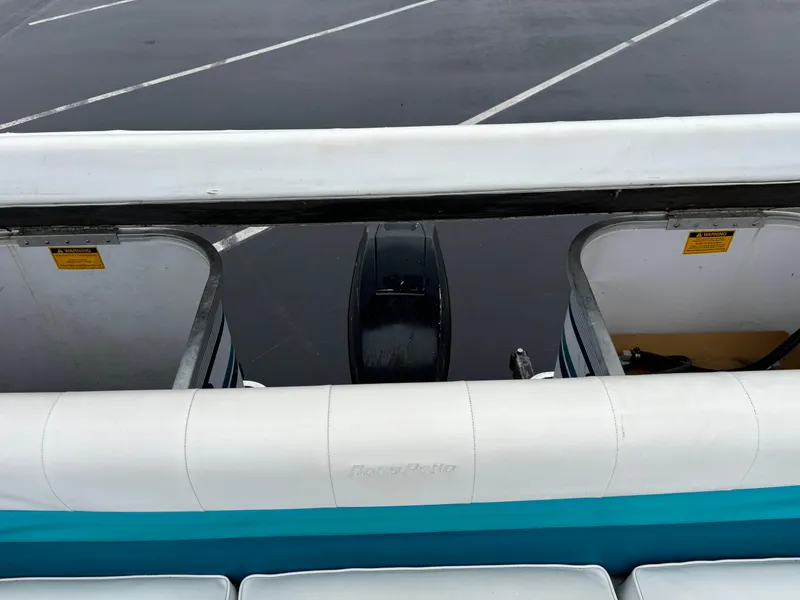 Slide: The Image of 1996 Godfrey Aqua Patio boat with outboard motor in a parking lot. - 5